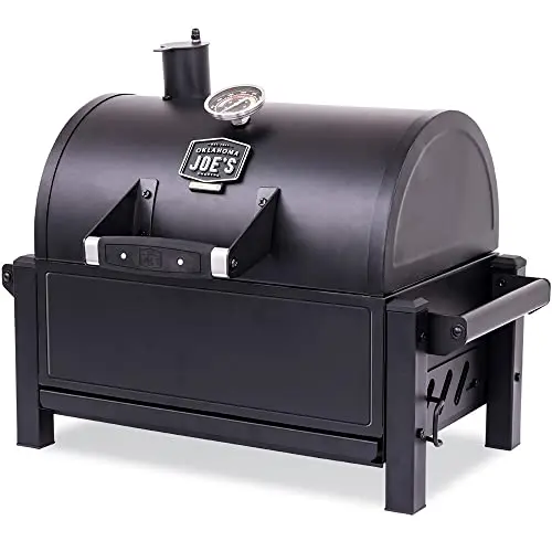 Black Oklahoma Joe's Rambler tabletop charcoal grill with a temperature gauge on the lid.
